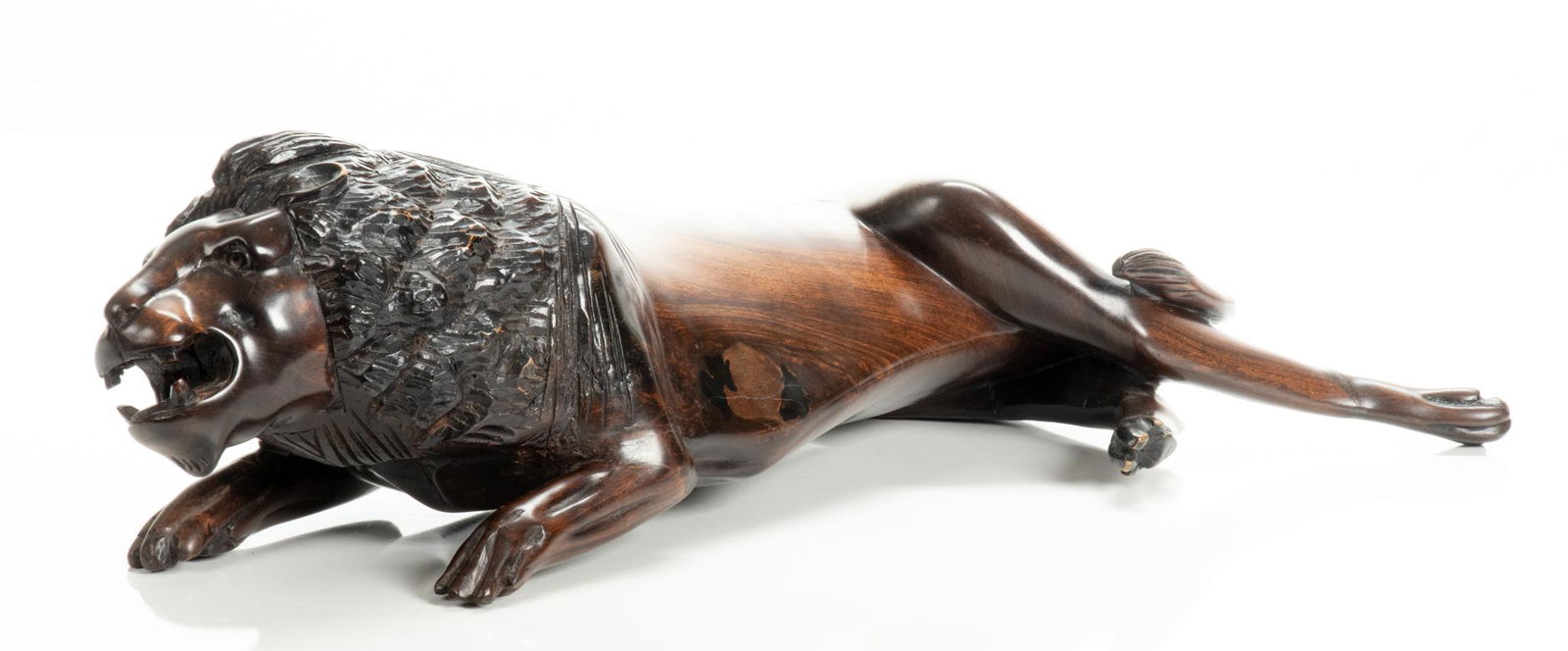 Jonathan Mwanza (Zambia) Carved Ebony Sculpture, H 5”, L 18”, Lion: JONATHAN MWANZA (ZAMBIA) CARVED EBONY SCULPTURE, H 5", L 18", LION A carved ebony sculpture by Jonathan Mwanza. Depicting a lion with mouth open laying down and stretching. Artist's signature incised