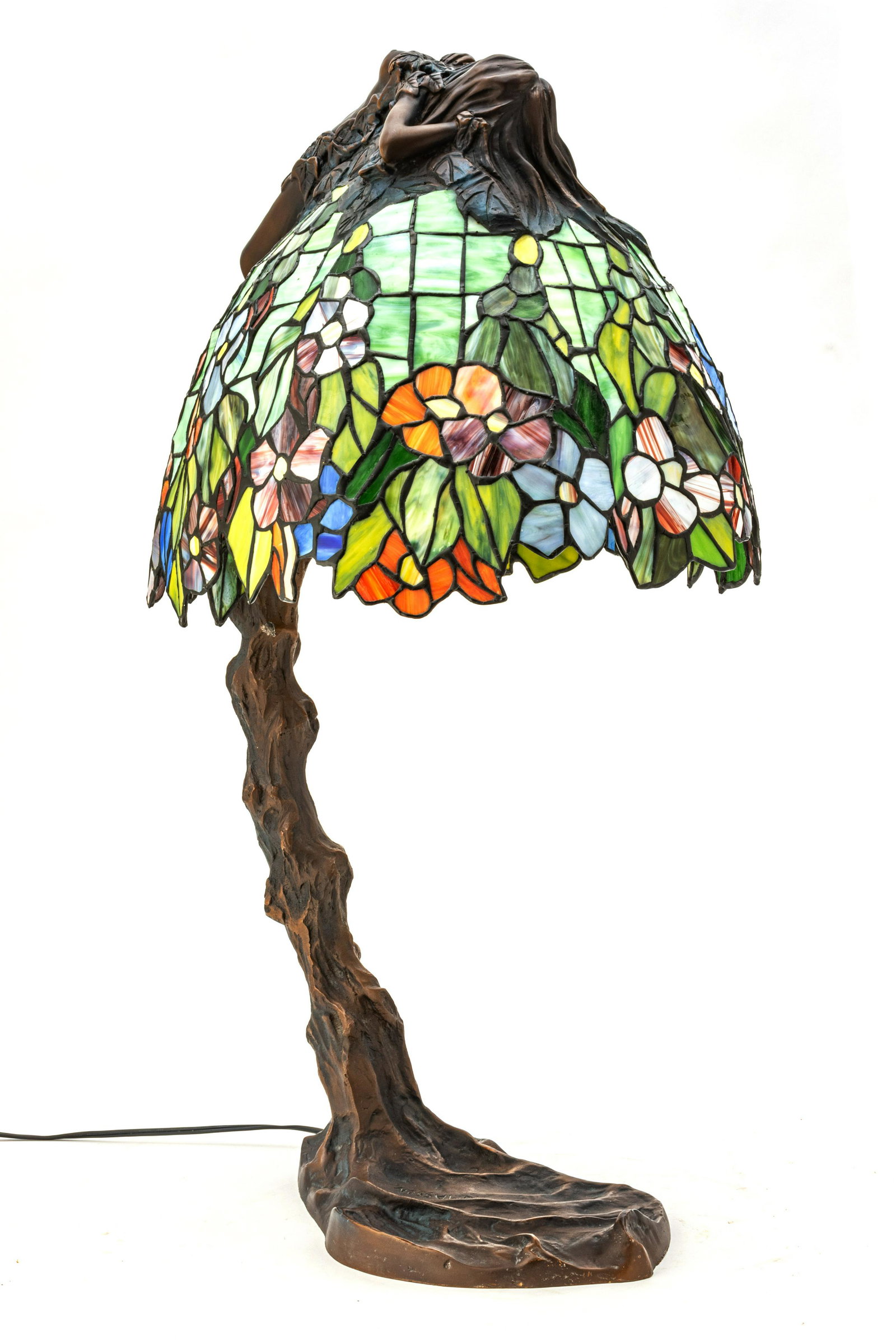 E. Thomasson, Bronze and Leaded Glass Table Lamp 1960 H 29” W 14” Reclining Nude: E. THOMASSON, BRONZE AND LEADED GLASS TABLE LAMP 1960 H 29" W 14" RECLINING NUDE Depth 16". Tree trunk stand with multi color leaded glass shade. Nude figure reclining on shade. From an Orchard Lake c