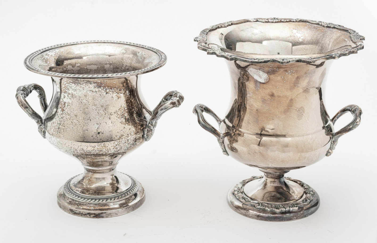 English Silverplate Champagne Coolers, 2 Pcs., H 9.25” and 11”: ENGLISH SILVERPLATE CHAMPAGNE COOLERS, 2 PCS., H 9.25" AND 11" Both having handles and pedestal bases. Silver plate. From a home on Bluff Drive, Harbor Springs, Mich.