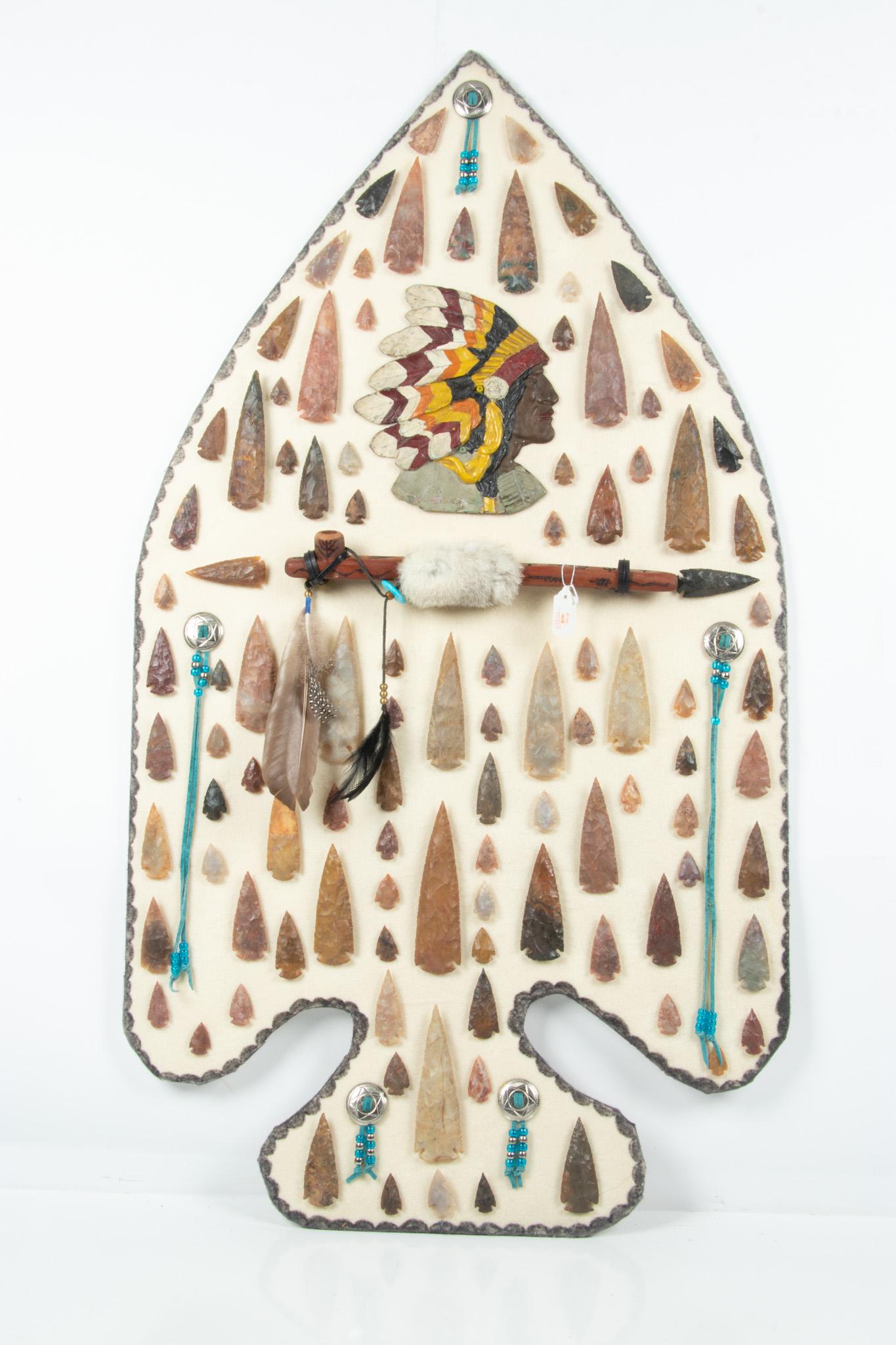 Stone Native American Arrowheads, Pipe and Painted Metal Profile of Native American Chief: STONE NATIVE AMERICAN ARROWHEADS, PIPE AND PAINTED METAL PROFILE OF NATIVE AMERICAN CHIEF APPROXIMATELY 100 Approx. 100 Arrowheads. Profile H 44", W 24". An amazing collection of genuine arrowheads.