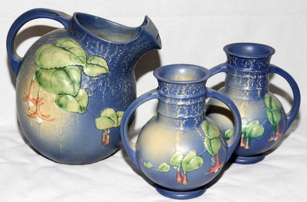 ROSEVILLE 'FUCHSIA' WATER PITCHER & VASES: ROSEVILLE 'FUCHSIA' POTTERY WATER PITCHER & VASES (2), H 6 1/2"-8", W 6"-8 1/2":Including 1 water pitcher, H.8", and 2 vases, H.6 1/2"; blue glaze, signed. Three pieces total.