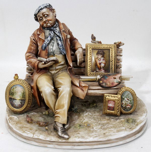 ANTONIO BORSATO, ITALIAN BISQUE FIGURE H 6 1/2": ANTONIO BORSATO, ITALIAN BISQUE FIGURE, H 6 1/2", ARTIST SEATED ON PARK BENCH:Rendered as an artist seated on a park bench, holding an open book, with his palette and paintings about; signed. Measures
