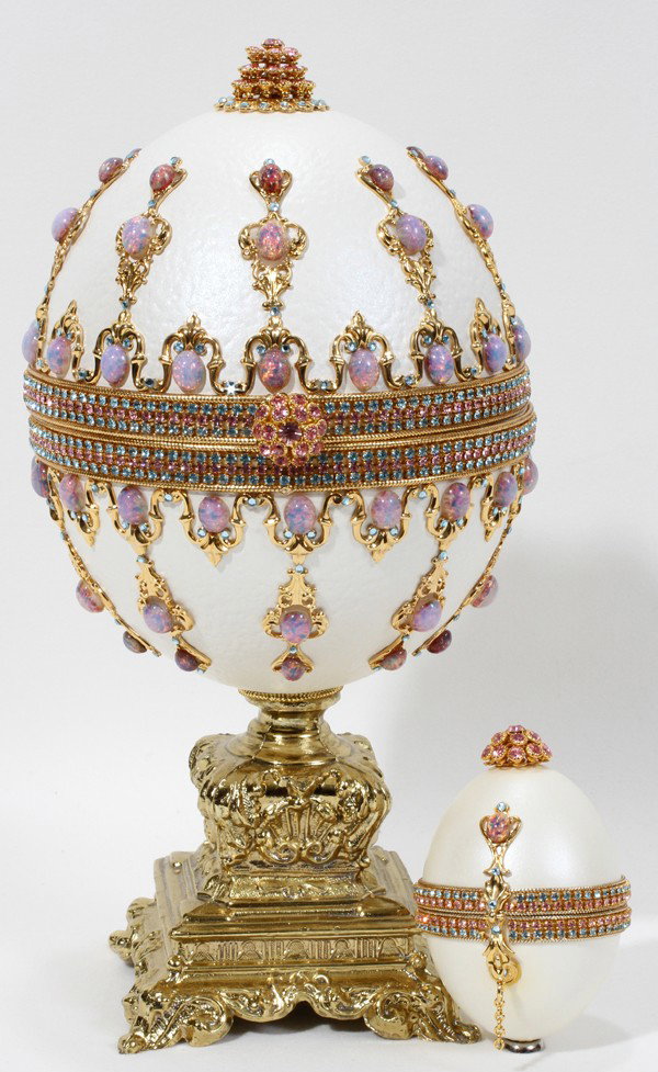FABERGE STYLE EGG-FORM MUSIC BOX & EGG-FORM BOX: FABERGE STYLE EGG-FORM MUSIC BOX & EGG-FORM BOX, H 10 1/2":A white ceramic egg-form box encrusted with faux jewels and raised on a gilt metal base, the underside fitted with a music box, hinges open t