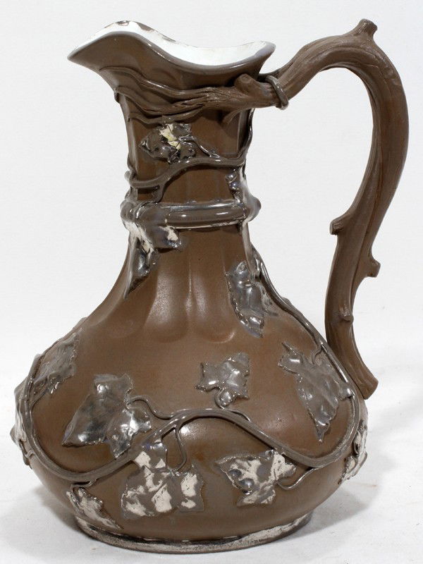 VILLEROY & BOCH EARTHENWARE EWER, C. 1845-1869,: VILLEROY & BOCH EARTHENWARE EWER, C. 1845-1869, H 8 1/2", L 8":Having a brown ground with silver luster accents on the leaf and vine motif clad ewer. Marked on the underside with trademark used from a