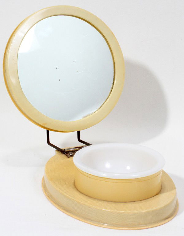 'IVORY' CELLULOID SHAVING MIRROR & DISH: 'FRENCH IVORY' CELLULOID SHAVING MIRROR & DISH, H 2 1/2",7" OPEN:Hinged mirror opens to reveal a glass insert. Marked "French K Ivory (with an arrow connecting it all)" at the underside.