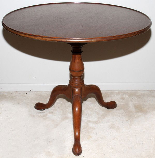 QUEEN ANNE STYLE MAHOGANY TILT-TOP TABLE: QUEEN ANNE STYLE MAHOGANY TILT-TOP TABLE, MID 20TH C., H 27 1/2", DIA 32":Circular top tilts on a bird cage mechanism, turned standard ending in three legs that end in a drake foot.