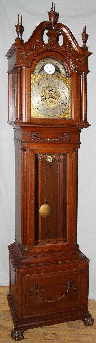 ELLIOT OF LONDON MAHOGANY GRANDFATHER CLOCK,: ELLIOT OF LONDON MAHOGANY GRANDFATHER CLOCK, H 99", W 27":With moon phase dial. H H 4627. Nine bells. Westminster & Whittington chimes. 3 brass clad weights. Second hand. Case having ribbon, bowknot, 