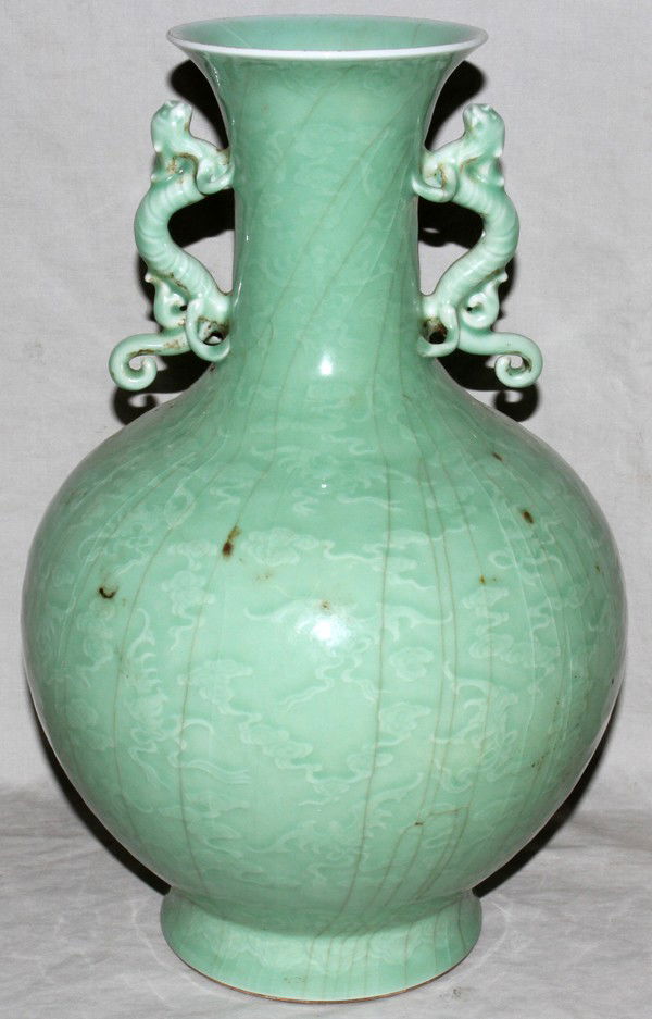 MODERN CHINESE INCISED PORCELAIN VASE: MODERN CHINESE INCISED PORCELAIN DOUBLE HANDLED VASE, H 15", DIA 10":Light green in color with foo lion handles and scenes of clouds and bats.
