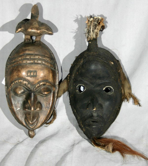 CEREMONIAL MASKS AFRICAN 2 PCS., H 16": CEREMONIAL MASKS AFRICAN 2 PCS., H 16":one depicts a man with feathers on top of head, animal hair on chin and is black in color; the other is a woman with a bird on the top of the head;