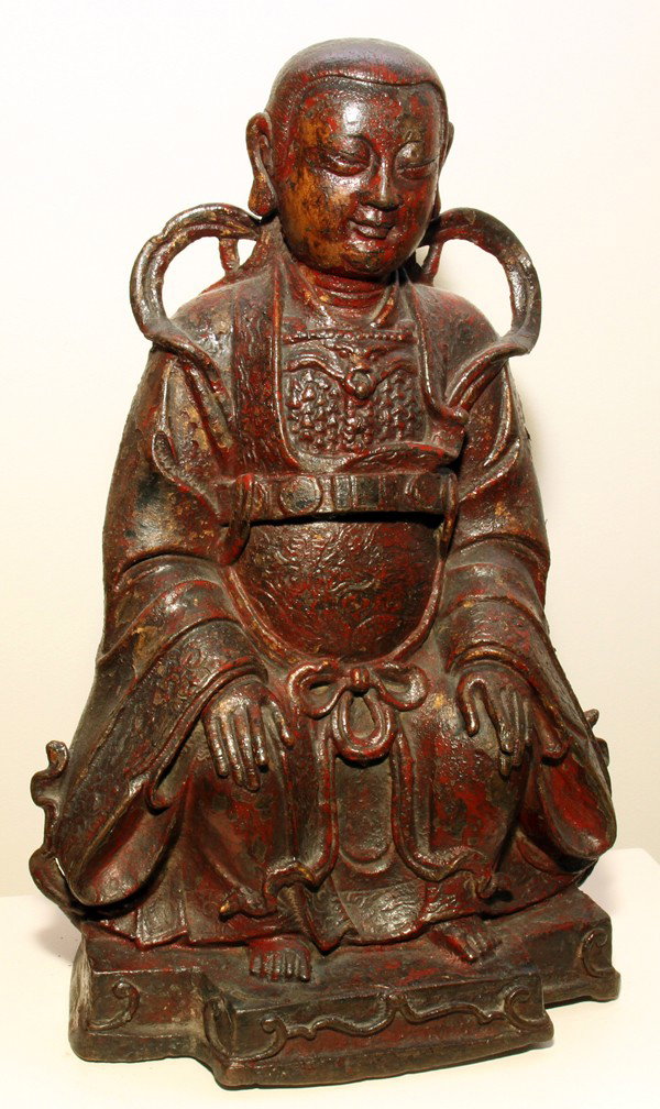 SOUTHERN CHINESE BRONZE BUDDHIST DIETY, C. 1500: SOUTHERN CHINESE RED LACQUER FINISH, BRONZE BUDDHIST DIETY, C. 1500, H 10":1st half of the Ming Dynasty; original red lacquer finish; inscription in Chinese characters is original and tells of the don