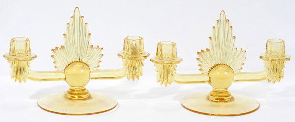 ART DECO STYLE TWO LIGHT GLASS CANDELABRAS,: ART DECO STYLE TWO LIGHT GLASS CANDELABRAS, PAIR, H 7", W 10":made of amber color molded glass with two lights each on horizontal arms; sunburst designs radiating from the spheres at the center of the