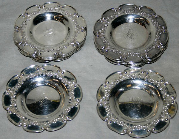 FRANK HERSCHEDE STERLING NUT DISHES, 12: FRANK HERSCHEDE STERLING NUT DISHES, 12:having a scalloped rims with floral designs in relief; monogram in the wells.