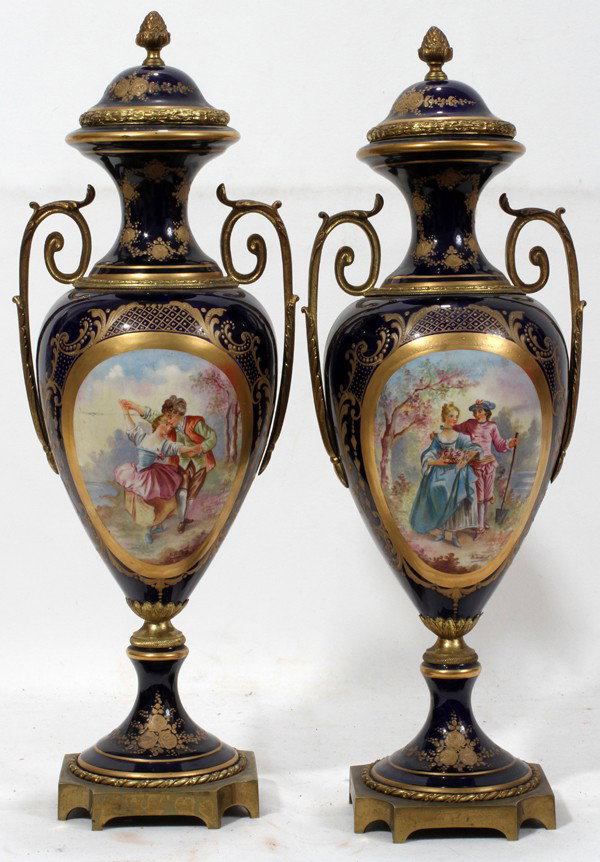 SEVRES SIGNED HAND PAINTED PORCELAIN URNS, PAIR: SEVRES SIGNED HAND PAINTED PORCELAIN URNS, PAIR, H 16":Cobalt blue with hand painted courting scenes. Signed B. Trehaut. Featuring bronze ormolu and acorn finials