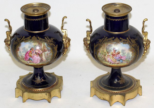 SEVRES SIGNED HAND PAINTED PORCELAIN URNS, PAIR: SEVRES SIGNED HAND PAINTED PORCELAIN URNS, PAIR, H 9", DIA 6 1/4":Cobalt blue with hand painted courting scenes. Signed Henry. Featuring bronze ormolu. Each without a lid.