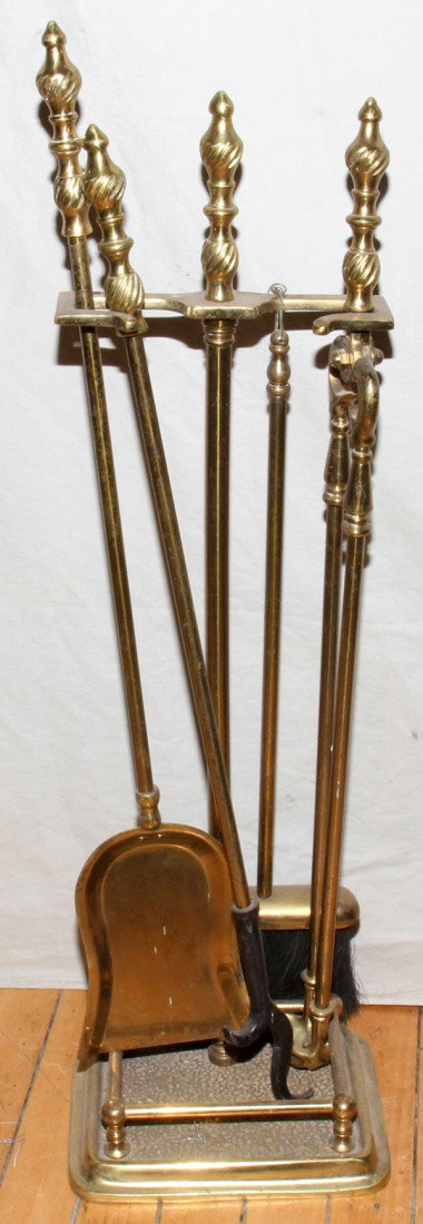 BRASS FIRETOOLS IN HOLDER, FIVE PCS.: BRASS FIRETOOLS IN HOLDER, FIVE PCS.:brass fire tools including a shovel, poker, broom and tongs in a brass stand.