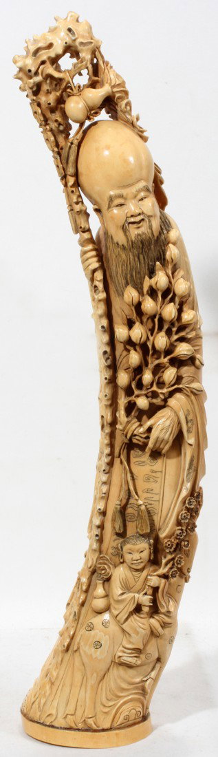 CHINESE CARVED IVORY FIGURE OF JUROJIN, H 26": CHINESE CARVED IVORY FIGURE OF JUROJIN, H 26":The figure of Jurojin, one of the Seven Lucky gods, with an elongated head, beard and knobby staff; signed at the underside. Includes separate wood stand.