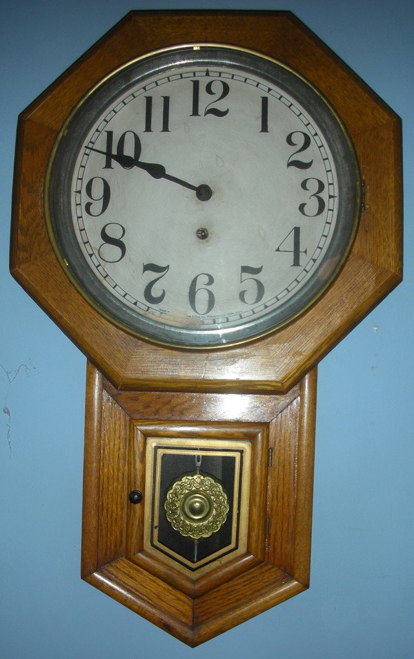 SESSIONS 'CLINTON' OAK WALL CLOCK, H 27", W 17": SESSIONS 'CLINTON' OAK WALL CLOCK, H 27", W 17":With key and pendulum. From the Estate of Robert and Elizabeth Mandy, Bingham Farms, Mi.