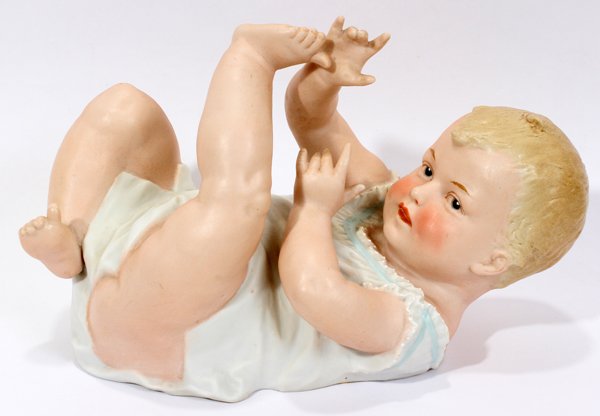 GERMAN BISQUE PIANO BABY CIRCA 1900 9": GERMAN BISQUE PIANO BABY CIRCA 1900, L 9":depicts a reclining infant; Hand painted