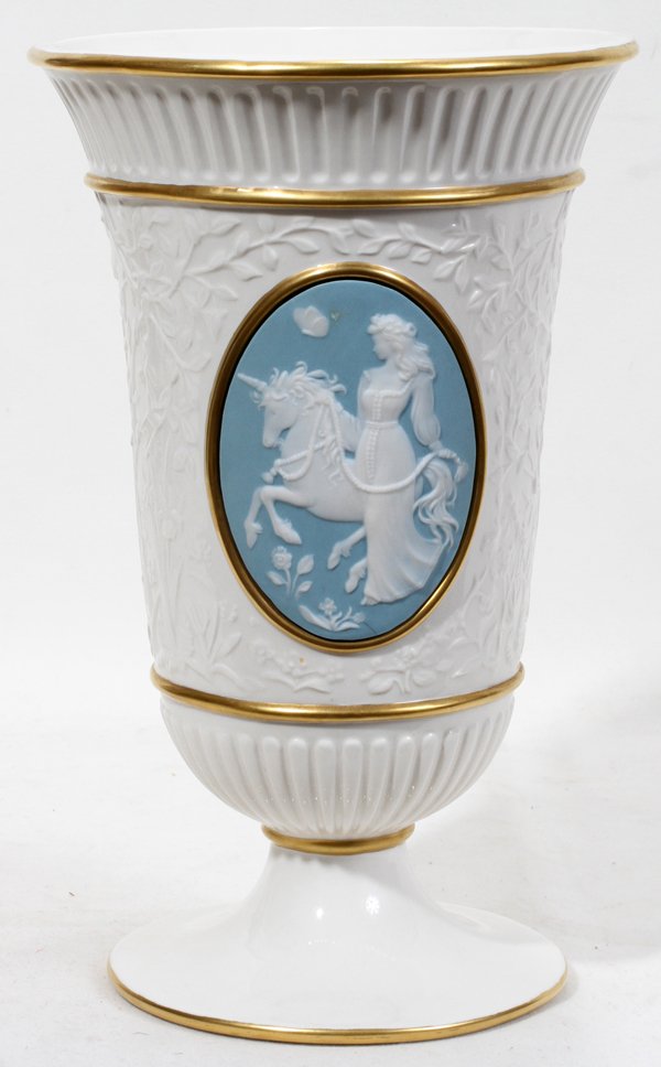 FRANKLIN MINT PORCELAIN VASE 11": FRANKLIN MINT PORCELAIN VASE, H 11":milk white porcelain pedestal vase, fluted at the rim and above short pedestal; body of the vase displays a cameo of a lady and a unicorn, butterfly and flowers on 