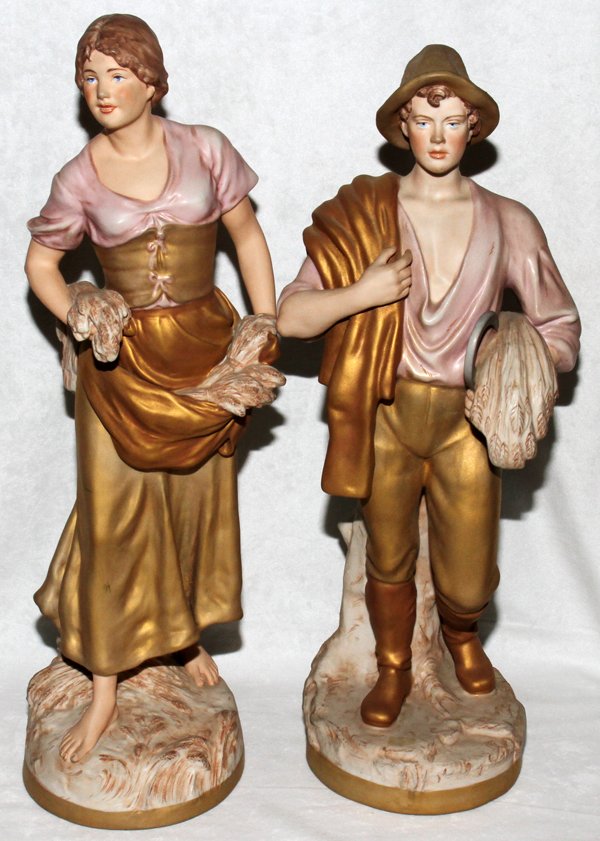ROYAL DUX PORCELAIN FIGURES PAIR 20": ROYAL DUX PORCELAIN FIGURES, PAIR, H 20":Provincial couple including a male figure with sheaf of wheat and sickle, 2445/52, and a woman with wheat in her apron, 1572/58. Additional marks at the unders