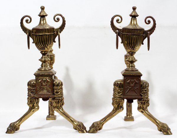 REGENCY STYLE BRASS OVER METAL ANDIRONS C. 1900: REGENCY STYLE BRASS OVER METAL ANDIRONS, C. 1900, PAIR, H 16":Each of urn-form with panel featuring crossed hunting horns and ribbon, on hoof feet.
