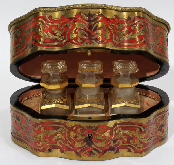 BOULLE CARTOUCHE SHAPE PERFUME BOX W/3 BOTTLES: BOULLE CARTOUCHE SHAPE PERFUME BOX FITTED WITH 3 FIRED GOLD GLASS PERFUME BOTTLES, H 4", L 7":19th c.; bottles are 3" high; box having tortoise sell inset with a brass scrolling vine motif.