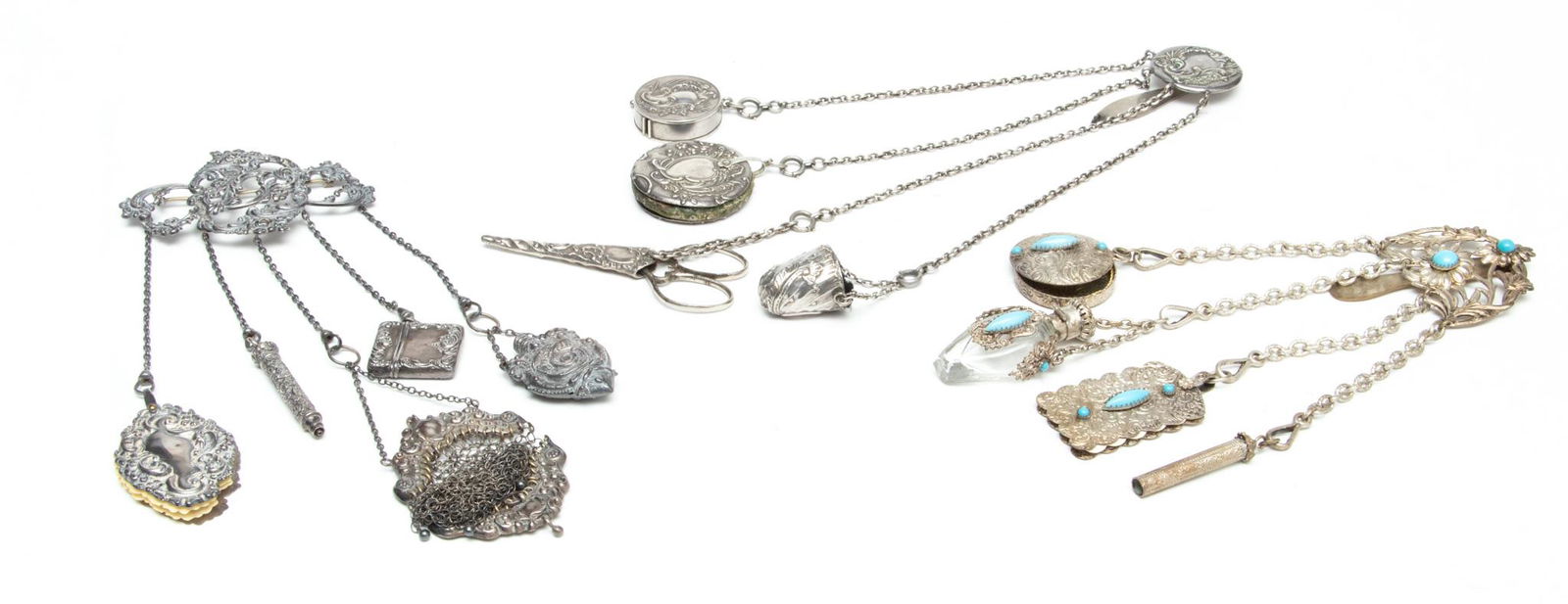 Group Of Chatelaines, 3 pcs: Group Of Chatelaines, 3 pcs | One L 12.25" having 4 chains including: tape measure, pin cushion, scissor holder with scissors, and thimble holder with thimble. One L 10" with scrolling leaf design and