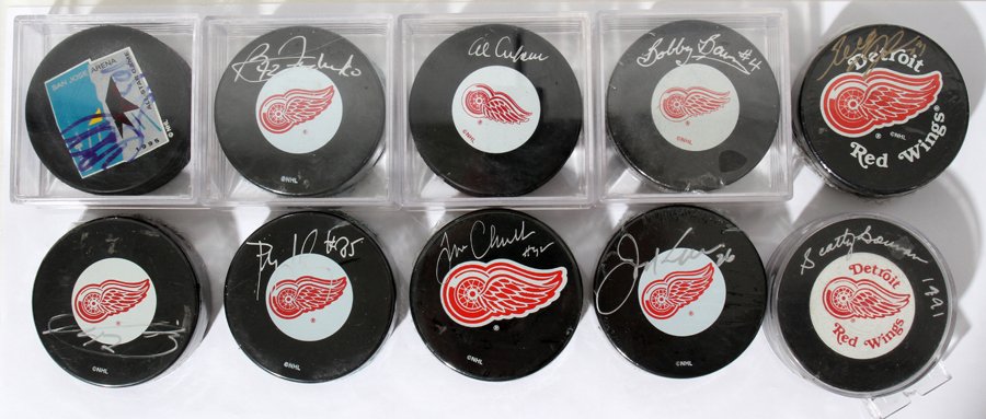 DETROIT RED WINGS AUTOGRAPHED HOCKEY PUCKS, 10: DETROIT RED WINGS AUTOGRAPHED HOCKEY PUCKS, 10 PCS.:nine NHL hockey pucks signed by individual players consisting of a 1995 All-Star Game puck signed by Steve Yzerman; eight NHL pucks individually sig