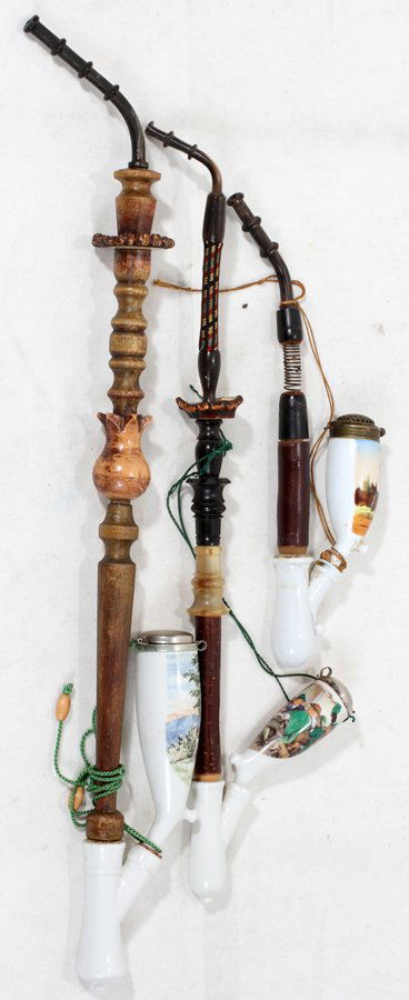 GERMAN PORCELAIN SMOKING PIPES, THREE: GERMAN PORCELAIN SMOKING PIPES, THREE:One pipe is L 11" and depicts a deer and doe in a landscape scene, the second is L 18" and depicts men in a tavern and the third depicts a hunter with his dog in