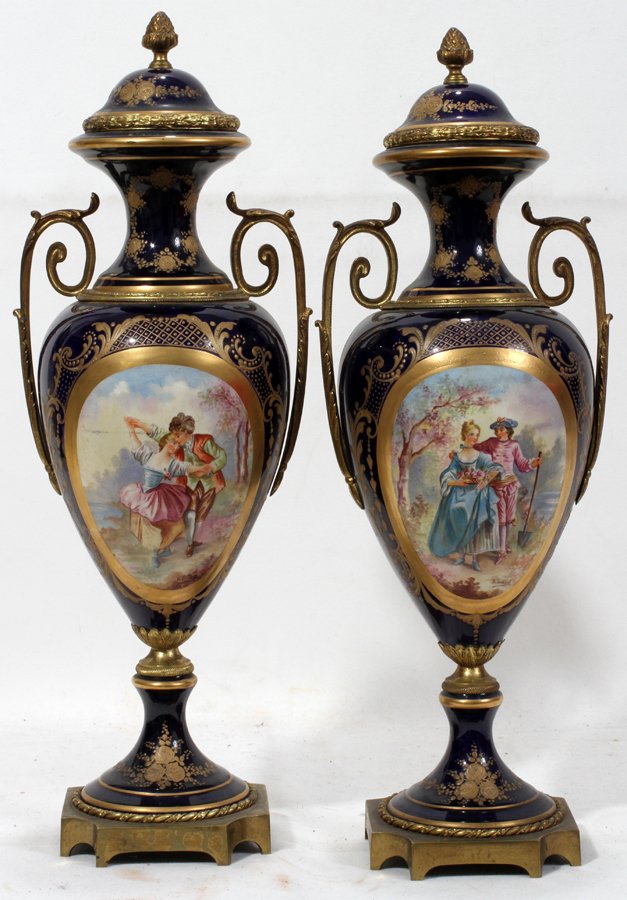 SEVRES SIGNED HAND PAINTED PORCELAIN URNS, PAIR: SEVRES SIGNED HAND PAINTED PORCELAIN URNS, PAIR, H 16":Cobalt blue with hand painted courting scenes. Signed B. Trehaut. Featuring bronze ormolu and acorn finials