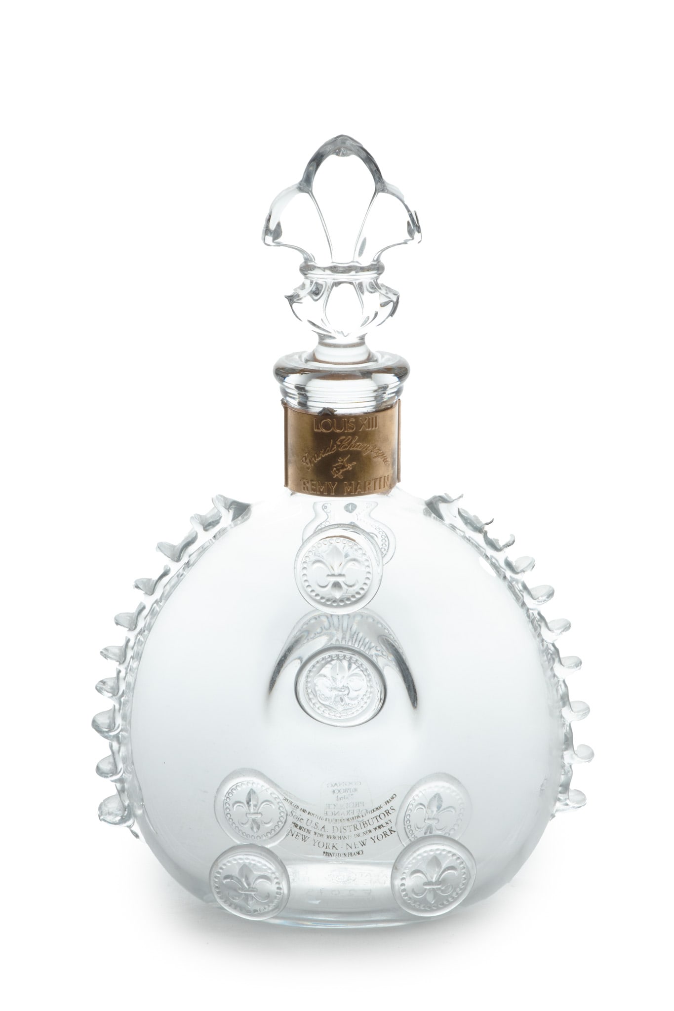 Baccarat (France) Remy Martin Crystal Liquor Bottle, H 11" W 7" Depth 3.5": Baccarat (France) Remy Martin Crystal Liquor Bottle, H 11" W 7" Depth 3.5" | Offers a fleur-de-lis form top, a gold tone band around the neck, and a spherical bodice. Bearing signature branding acid e