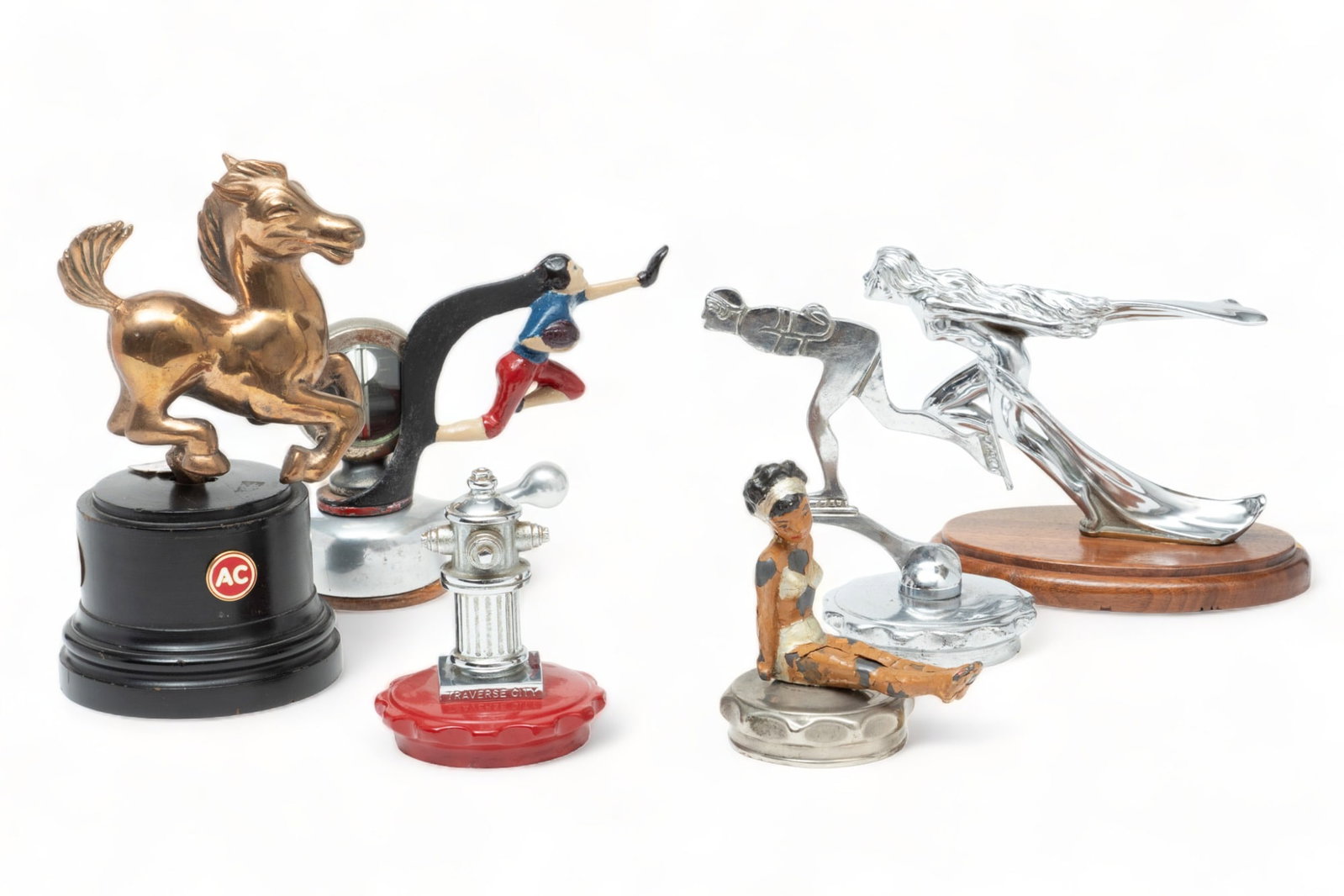 American Motor Mascots (5) And One Trophy, Ca. 20th C., 6 pcs: American Motor Mascots (5) And One Trophy, Ca. 20th C., 6 pcs | Lot includes one goddess mascot. Zinc die cast and chrome plated. Mounted to a wooden base, H 4.5", W 1", L 6". One painted lead figure 