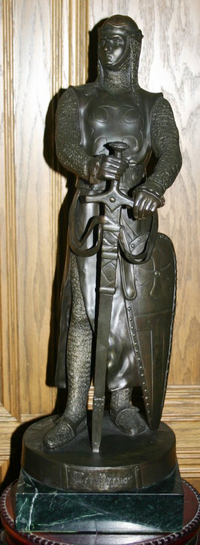AFTER MAURICE TARCA (FRENCH) BRONZE SCULPTURE: AFTER MAURICE TARCA (19TH C FRENCH) BRONZE SCULPTURE 23" H. "LE PREUR":depicts an medieval knight dressed in full armor with hands resting on a sword pointed into the ground. Signed on base. Green mar