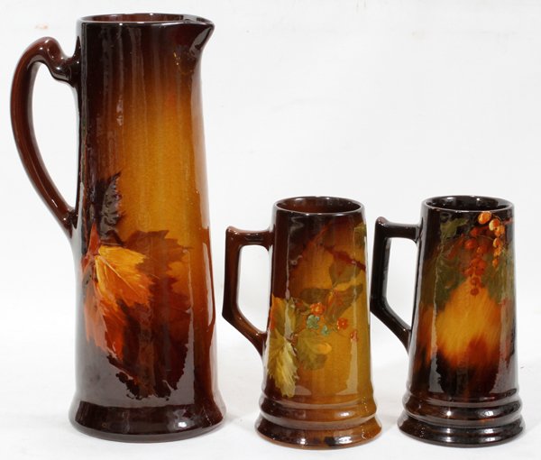 J.B. OWENS 'UTOPIAN' POTTERY PITCHER: J.B. OWENS 'UTOPIAN' POTTERY PITCHER AND TWO TANKARDS, THREE, H 7" - 12":includes a hand painted and glazed pottery pitcher, 12" H. decorated with motifs of autumn leaves along with 2 steins, 7" H. wi