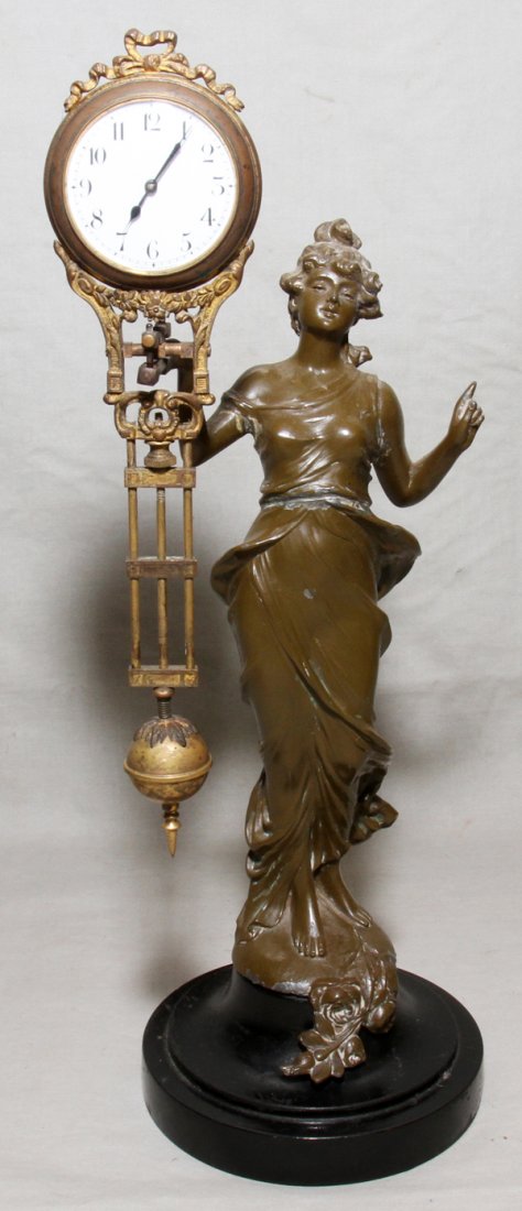 JUNGHANS PATINATED METAL FIGURAL SWINGER CLOCK,: JUNGHANS PATINATED METAL FIGURAL SWINGER CLOCK, EARLY 20TH C.:Art nouveau style standing female figure with a swinging clock balancing in her right hand.
