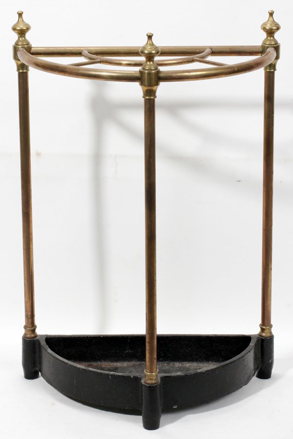 BRASS & IRON UMBRELLA STAND, EARLY 20TH C., H 2: BRASS & IRON UMBRELLA STAND, EARLY 20TH C., H 21", W 15 1/2":Demi lune shape, brass supports and finials, iron base.