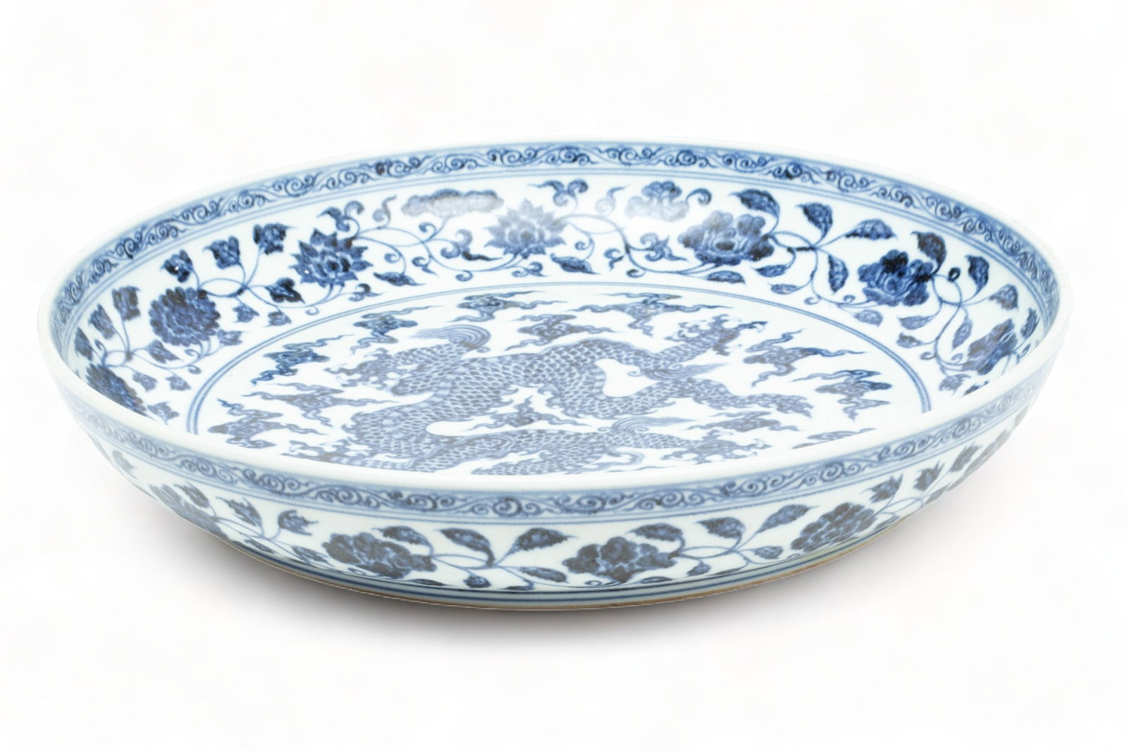 Chinese Ming Dynasty Style Blue And White Porcelain Disc, H 3" Dia. 17": Chinese Ming Dynasty Style Blue And White Porcelain Disc, H 3" Dia. 17" | Dragon motif at center with band of flowers. Unmarked. Yongle (??) style.