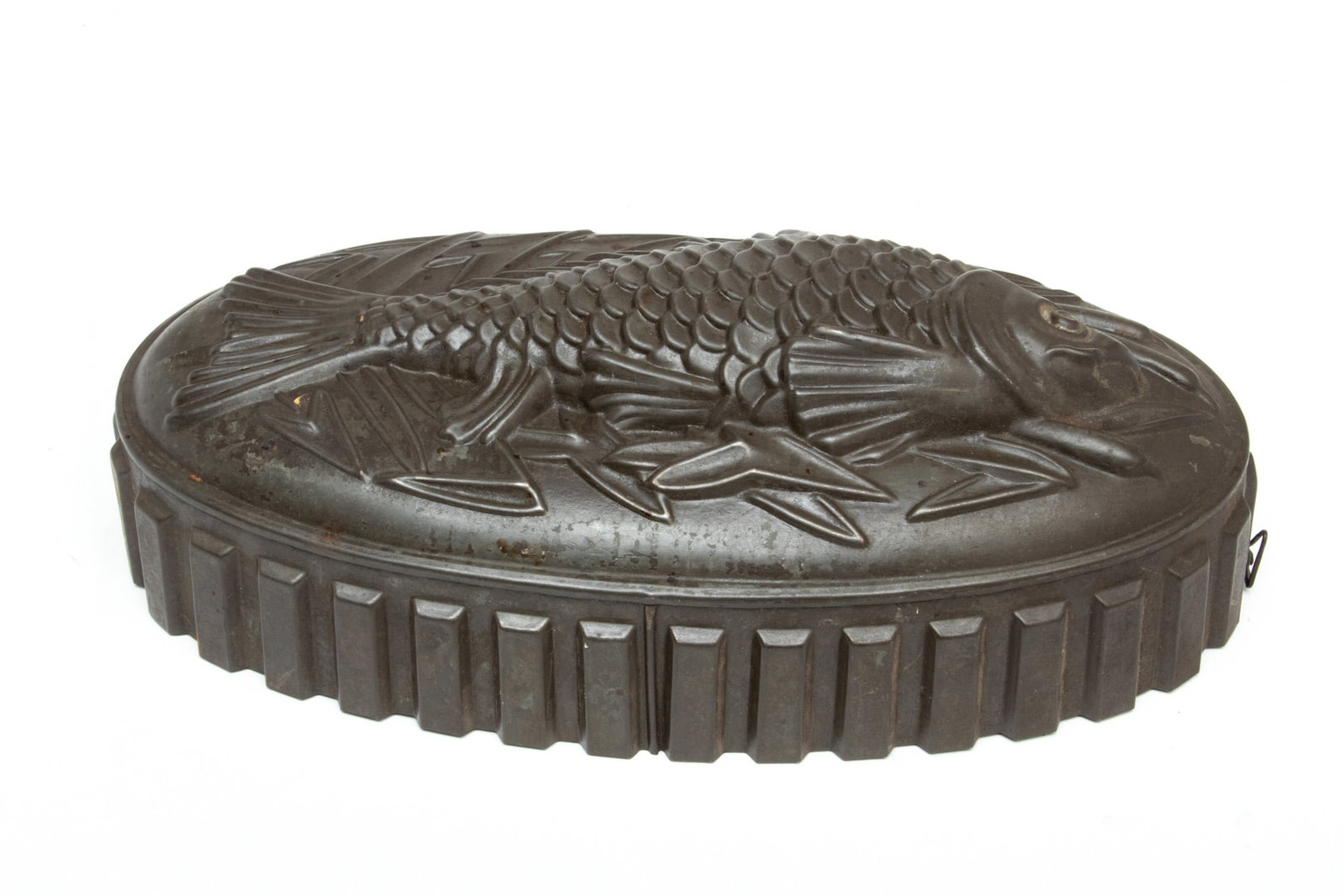 Tin Mold, Ca. 1900, Fish Form, H 4" W 5.5" L 12": Tin Mold, Ca. 1900, Fish Form, H 4" W 5.5" L 12" | the tin mold offers a fish and herb motif with notched edge. Offers a hook for wall hanging. Circa 1900.