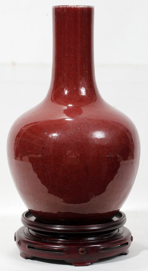 SANG DE BOEUF POTTERY VASE, H 14 1/2", DIA 9": SANG DE BOEUF POTTERY VASE, H 14 1/2", DIA 9":Having a bulbous form to a tapered neck accompanied by a wood base.