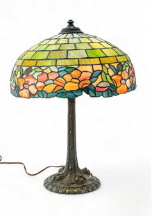 Wilkenson Art Glass Table Lamp, Ca. 1915, "Geometric with Floral Band", H 23.5" Dia. 18.5": Wilkenson Art Glass Table Lamp, Ca. 1915, "Geometric with Floral Band", H 23.5" Dia. 18.5" | Five rows of white to green mosaic glass panels drop to a floral band. on a #323 Base with a Renaissance br