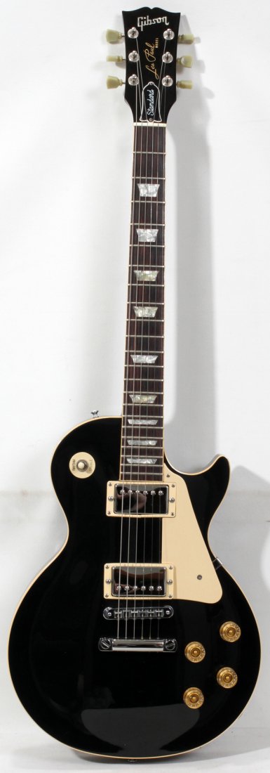 GIBSON LES PAUL STANDARD ELECTRIC GUITAR,: GIBSON LES PAUL STANDARD ELECTRIC GUITAR, #82458567:Black body and mother-of-pearl insert in neck. Rhythm treble switch, acrylic tuning keys. In fitted case. Made in 1988.