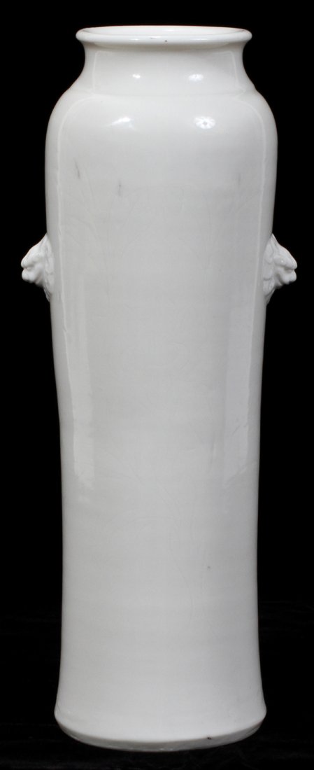 CHINESE BLANC DE CHINE PORCELAIN VASE: CHINESE BLANC DE CHINE PORCELAIN CYLINDRICAL VASE, C. 1800, H 13 1/2", DIA 4 1/2":White glaze with slightly inverted sides, incised foliate decoration and foo lion masks. Unglazed base. No apparent ma