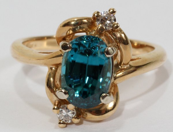 14KT YELLOW GOLD, BLUE ZIRCON & DIAMOND RING: 14KT YELLOW GOLD, BLUE ZIRCON & DIAMOND RING:A 14kt yellow gold mount centered by an oval blue zircon, with diamond accents. Size 6.