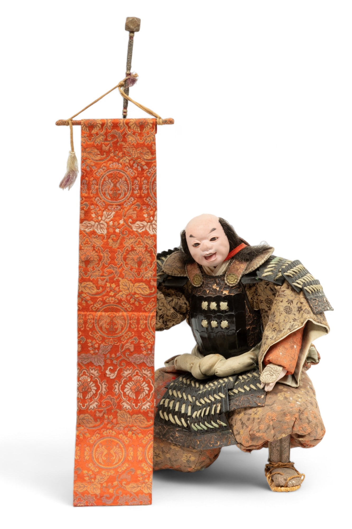 Japanese Ningyo Retainer/Standard Bearer Doll H 16.5" W 9" Depth 7": Japanese Ningyo Retainer/Standard Bearer Doll H 16.5" W 9" Depth 7" | Depicted kneeling in battle attire of brocade silk and ornamentation while bearing a standard. Provenance: Property from a Southfi