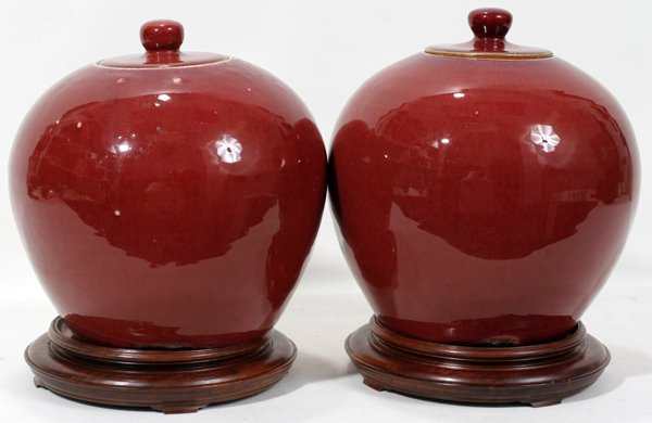 SANG DE BOEUF POTTERY COVERED JARS, PAIR, H 8": SANG DE BOEUF POTTERY COVERED JARS, PAIR, H 8", DIA 9":Chinese. Having a bulbous form and accompanied by wood bases.