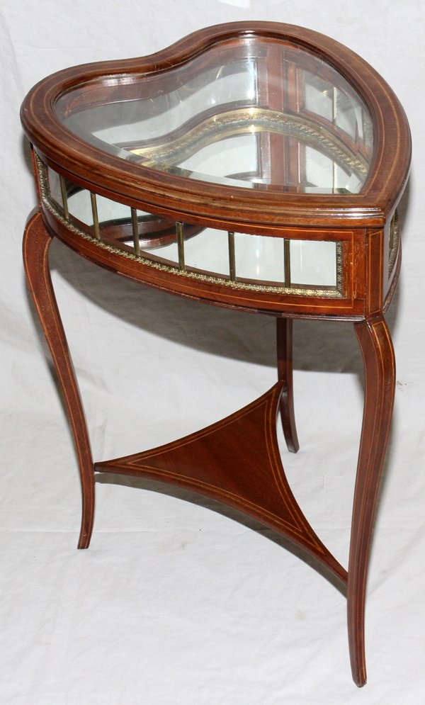 MAHOGANY & SATINWOOD CURIO TABLE, C. 1930: MAHOGANY & SATINWOOD CURIO TABLE, C. 1930, H 29", W 16", L 20":Heart-form beveled glass top hinges open to mirrored base, raised on three legs joined by a stretcher.
