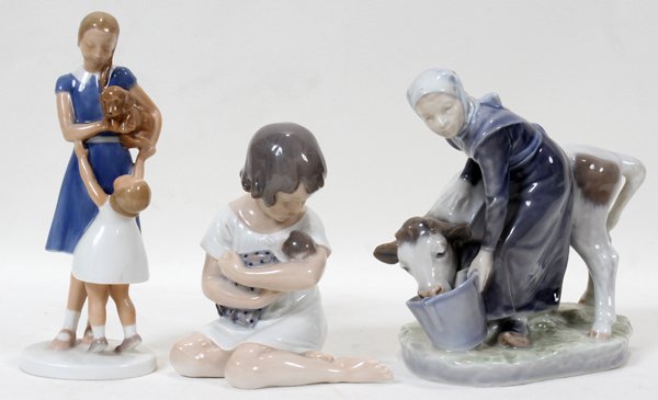 ROYAL COPENHAGEN & BING & PORCELAIN FIGURES: ROYAL COPENHAGEN AND BING & GRONDAHL PORCELAIN FIGURES, THREE, H 5"-7":Royal Copenhagen porcelain figures include 1 seated girl cradling doll, number 1938, and 1 milkmaid offering water to a cow, numb