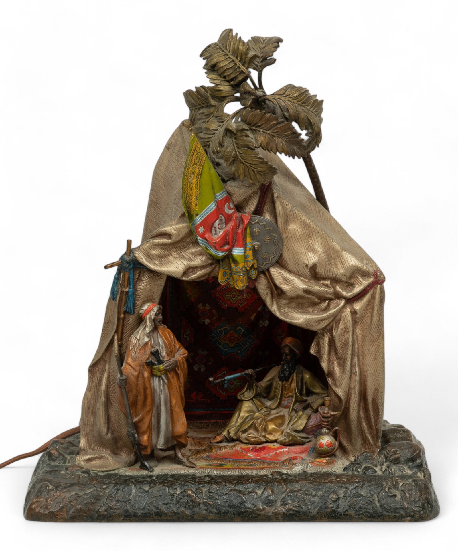 Anton Chotka (Austrian, 1875-1925) Cold Painted Bronze Sculpture - Bedouin in Tent, Table Lamp Ca.: Anton Chotka (Austrian, 1875-1925) Cold Painted Bronze Sculpture - Bedouin in Tent, Table Lamp Ca. 1910, H 15" W 12.5" Depth 8" | Arabian theme with Bedouin smoking a long pipe and seated on a carpet 