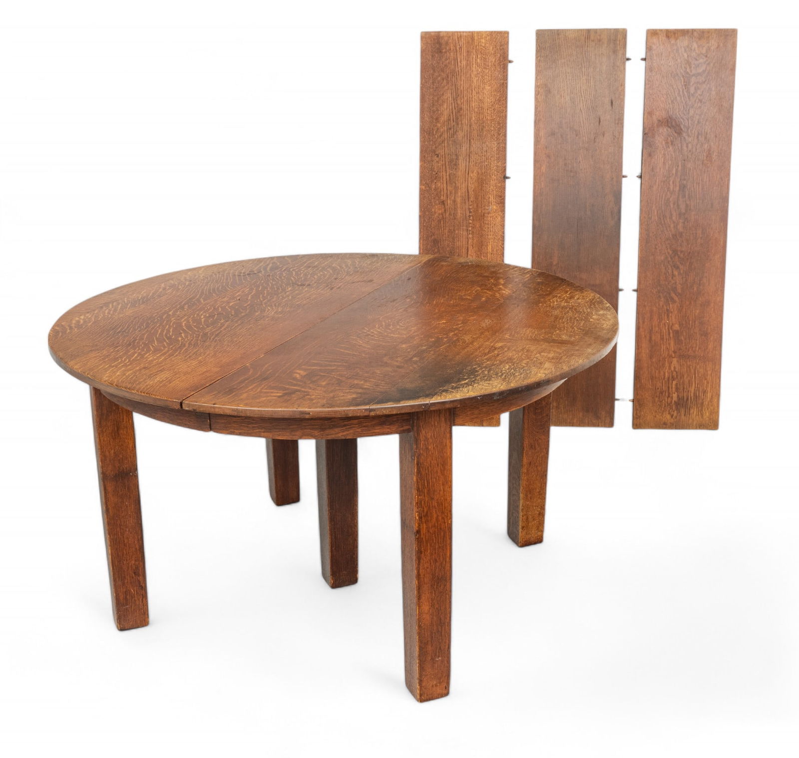 Mission Period Oak Dining Table, Ca. 1900, H 29.25" Dia. 54": Mission Period Oak Dining Table, Ca. 1900, H 29.25" Dia. 54" | the table includes three leaves, measuring L 54" X W 12". Bearing partial paper label to the underside. Provenance: Property from an Ann