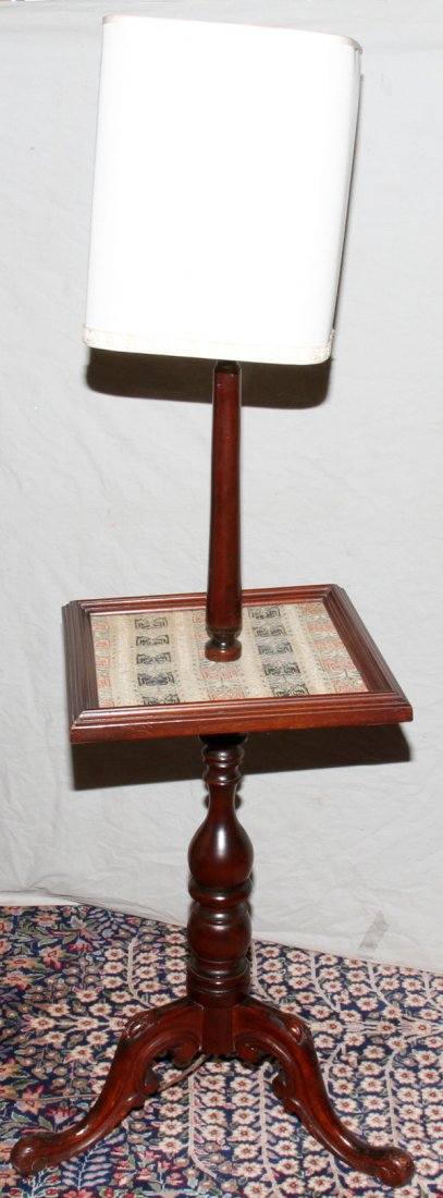 GEORGIAN STYLE MAHOGANY FLOOR LAMP WITH NEEDLEW: GEORGIAN STYLE MAHOGANY FLOOR LAMP WITH NEEDLEWORK TABLE-TOP, C. 1930, H 55", W 16 1/2":Baluster-turned standard centered by a table top with needlework covering, on three cabriole legs with carved kn